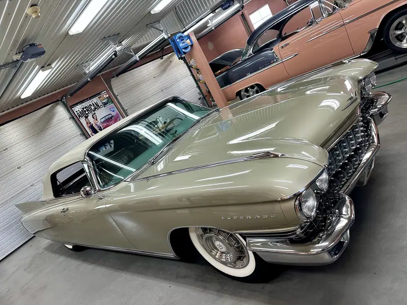 Beige Cadillac Eldorado cabriolet med vit sufflett och vita däcksidor i kundens garage.