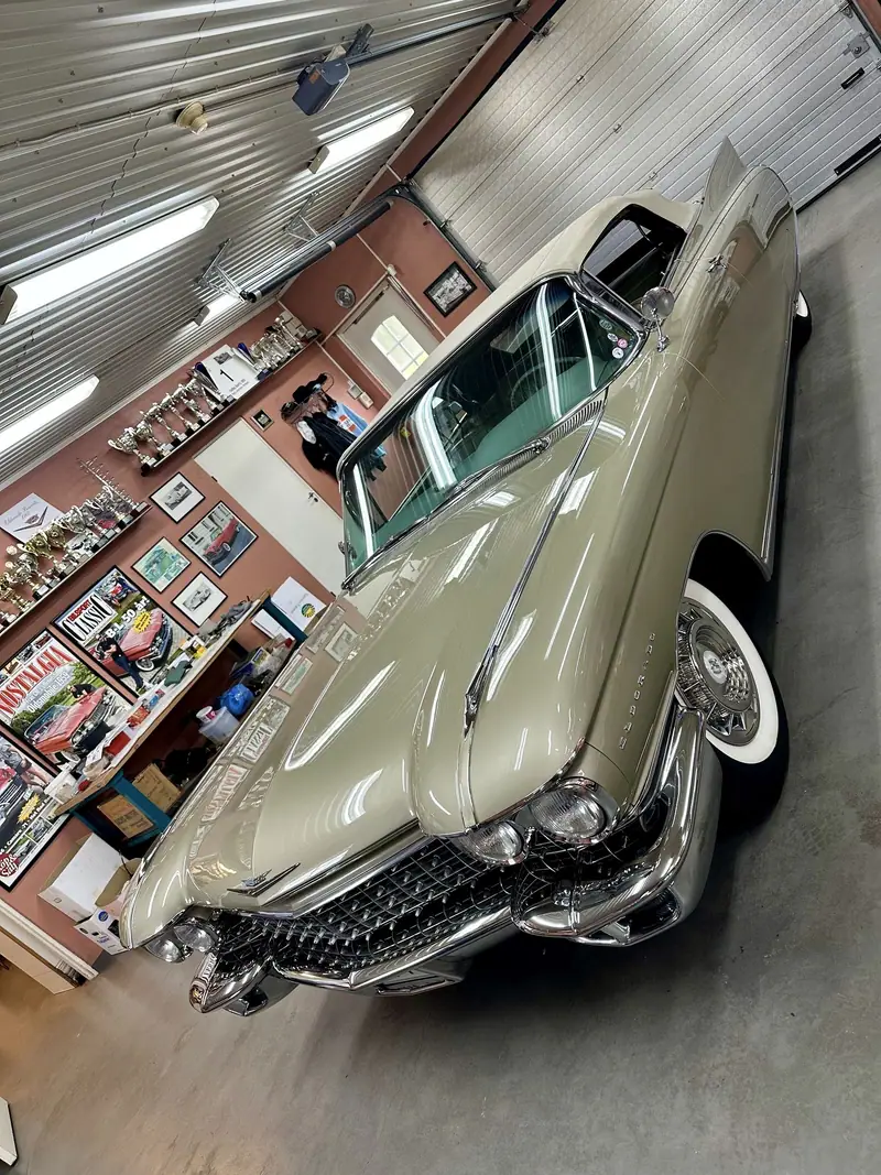 Den beige Cadillac Eldorado snett framifrån med kromad grill och dubbla strålkastare i kundens garage.