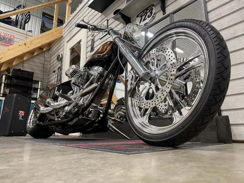 Motorcykeln snett framifrån med blank kromad framfälg och framgaffel.