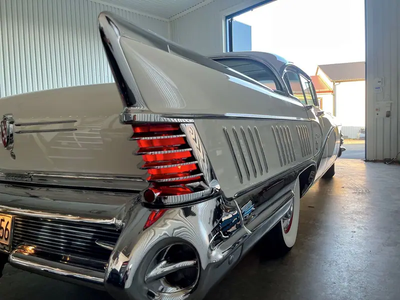 Den höga stjärtfenan på en silverfärgad Cadillac från 1959 med dubbla röda baklyktor.