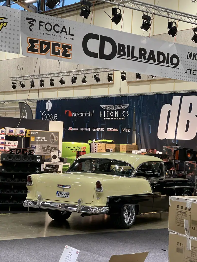 Den svarta och gula Chevrolet Bel Air från 1955 bakifrån i en monter på en bilmässa.