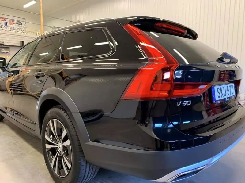 Svart Volvo V90 Cross Country fotograferad snett bakifrån i verkstaden.