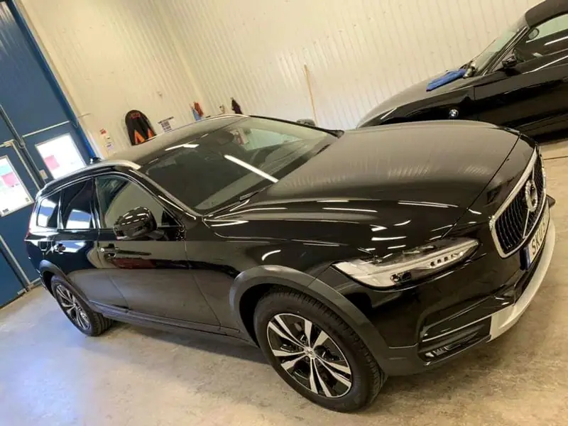 Svart Volvo V90 Cross Country fotograferad snett framifrån i verkstaden.