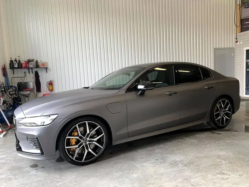 Grå Volvo S60 med guldfärgade bromsok i verkstaden.