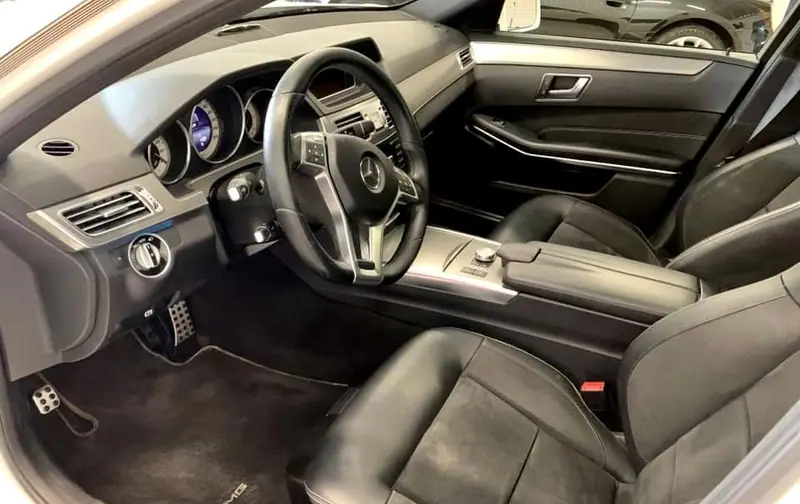 Förarplats och mittkonsol i en Mercedes med svart skinnklädsel.